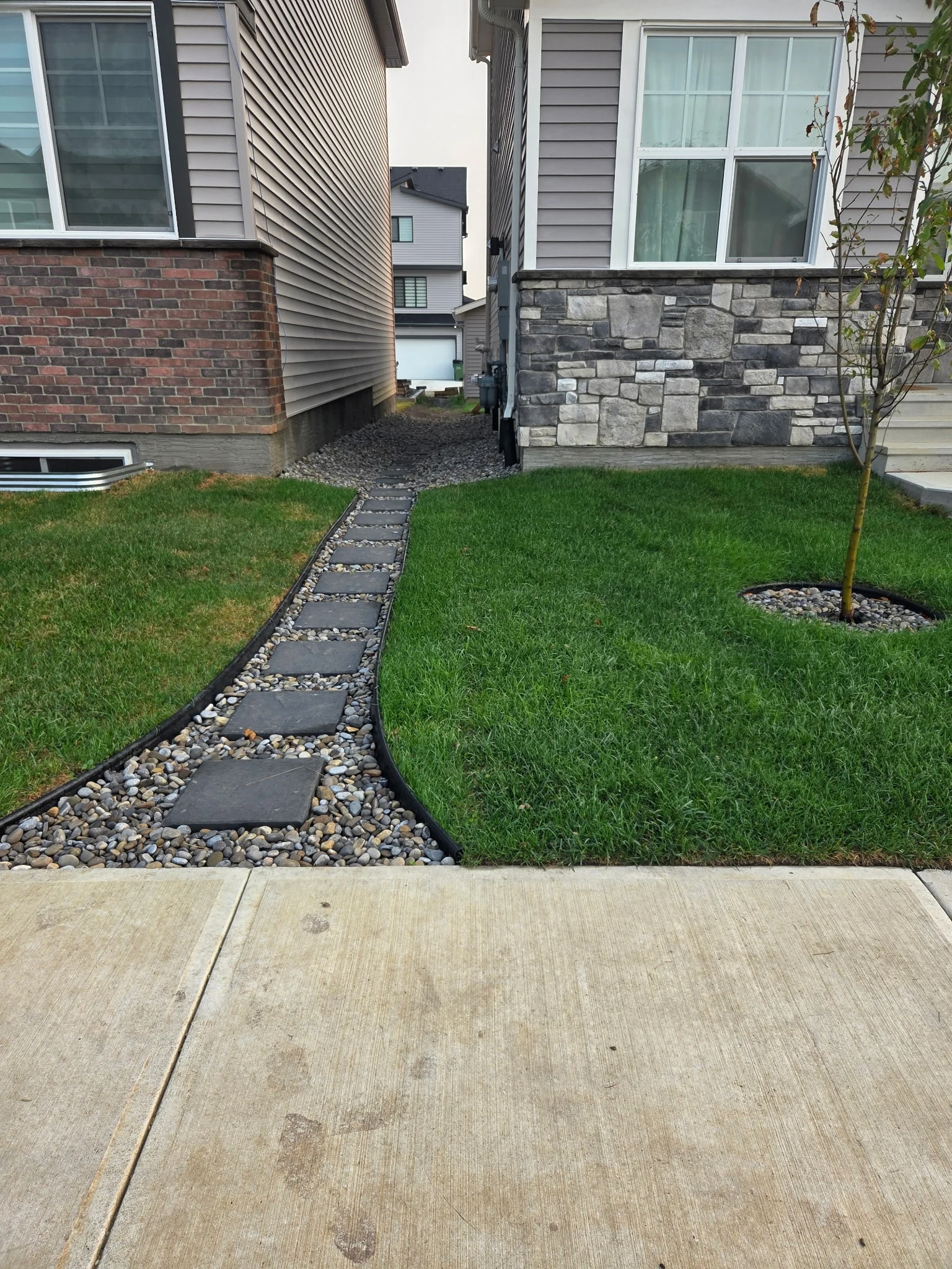 Finished front yard with sod, tree and rock beds